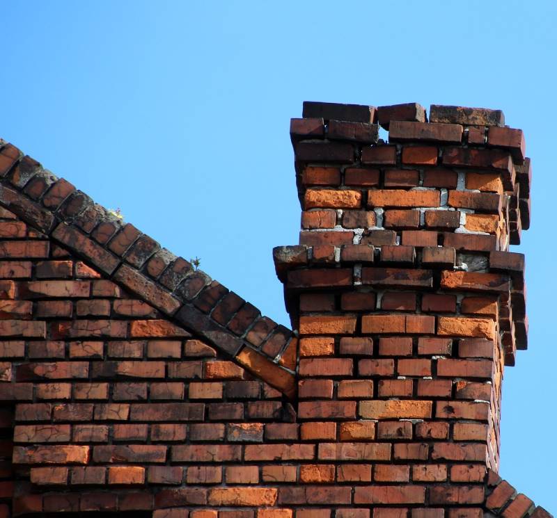 Signs Your Boston Home Needs a Chimney Inspection Blog Article - Damaged chimney on an Boston home showing cracks and missing mortar